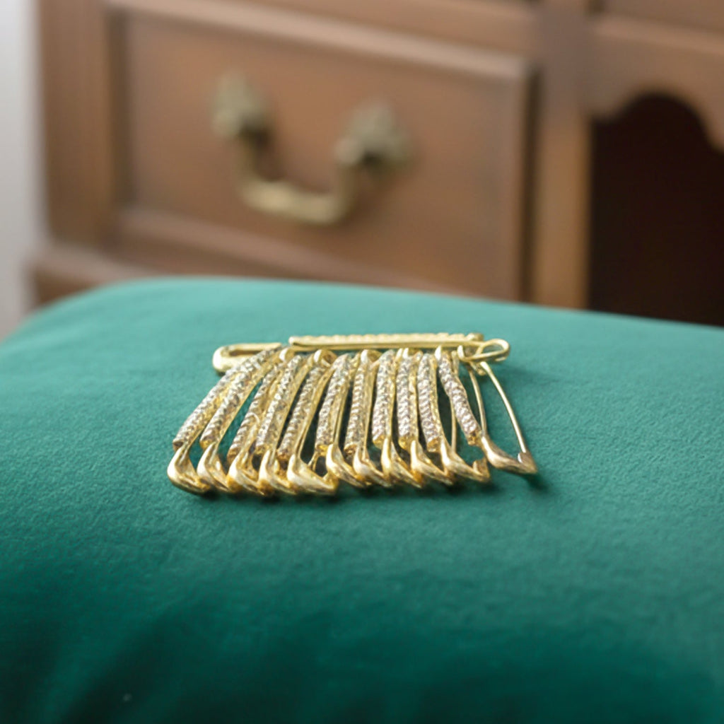 Boxed 12-piece set of elegant golden safety pin brooches