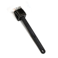 Black silicone toilet brush with its draining holder, ready for use in a modern bathroom.