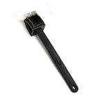 Black silicone toilet brush with its draining holder, ready for use in a modern bathroom.