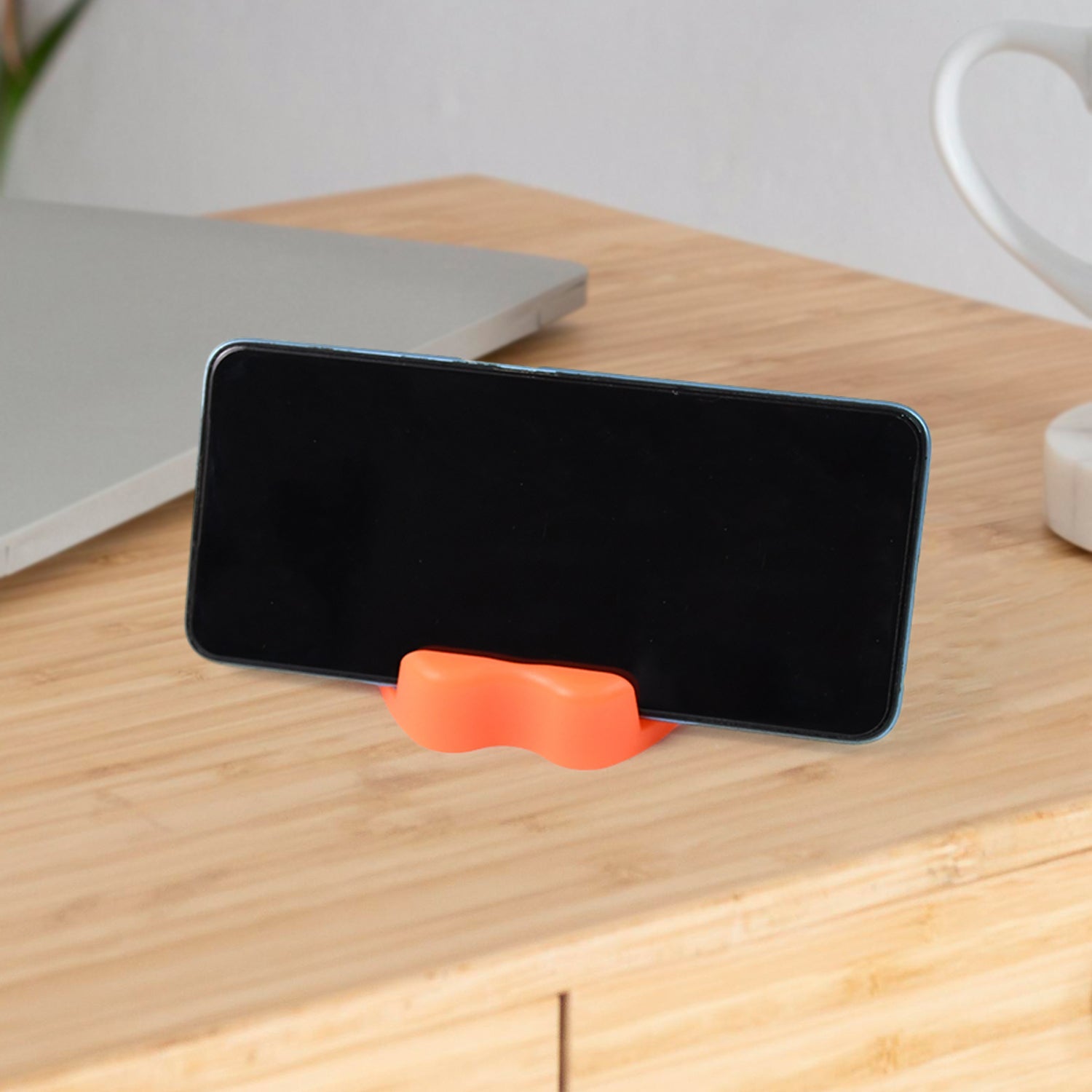 Durable apple-shaped plastic holder for smartphone at desk