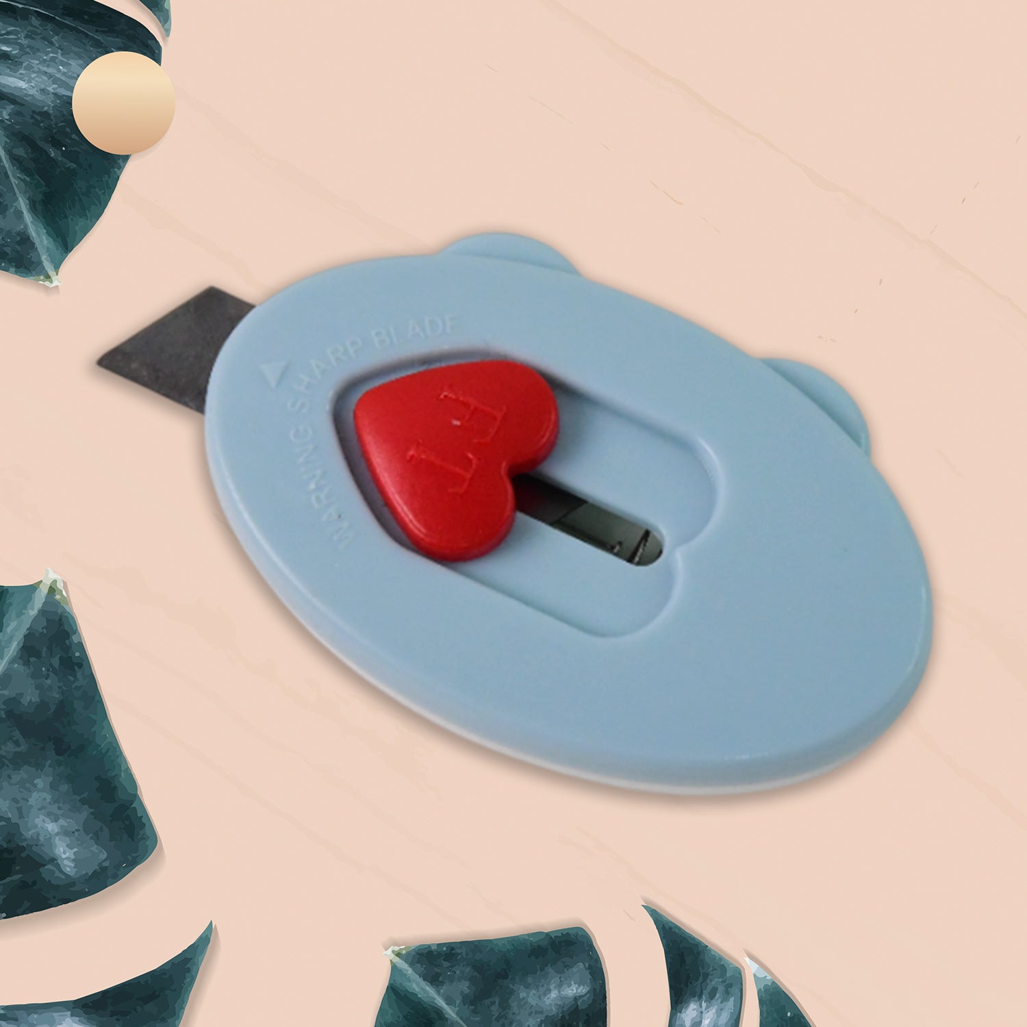 Heart-shaped safety lock on mini utility cutter for secure cutting