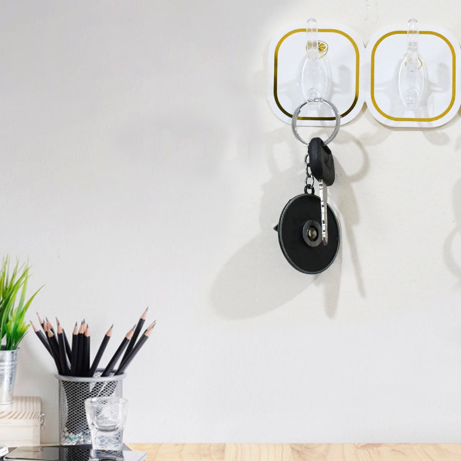 Transparent adhesive wall hook securely holding a heavy object, demonstrating its 3kg load capacity.