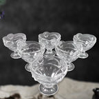 Three glass dessert bowls displayed from an angle, emphasizing their clear finish.