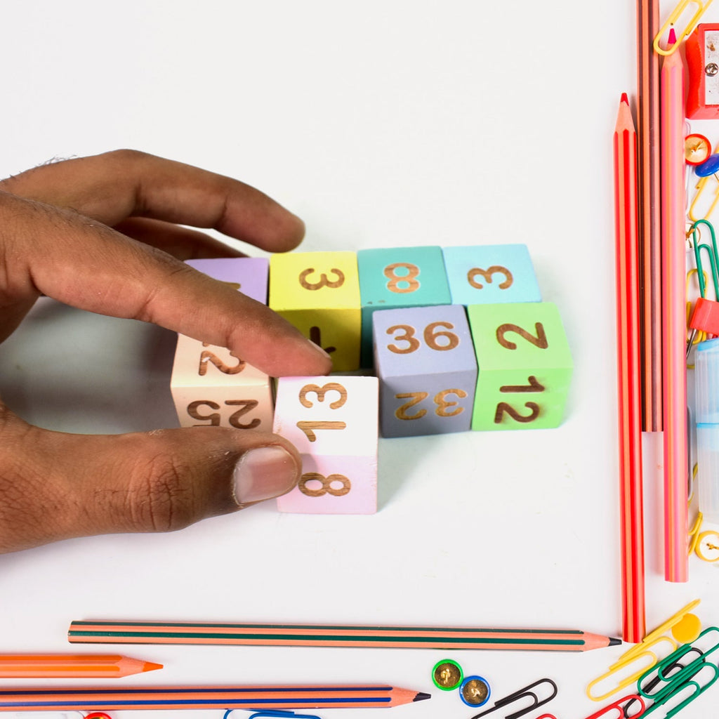 Various wooden number and symbol pieces from the Aditi educational math game.