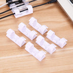 A set of white plastic cable clips with strong adhesive backing displayed on a clean surface.