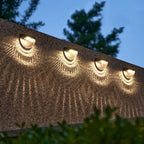 Outdoor solar fence light with honeycomb shade illuminating garden
