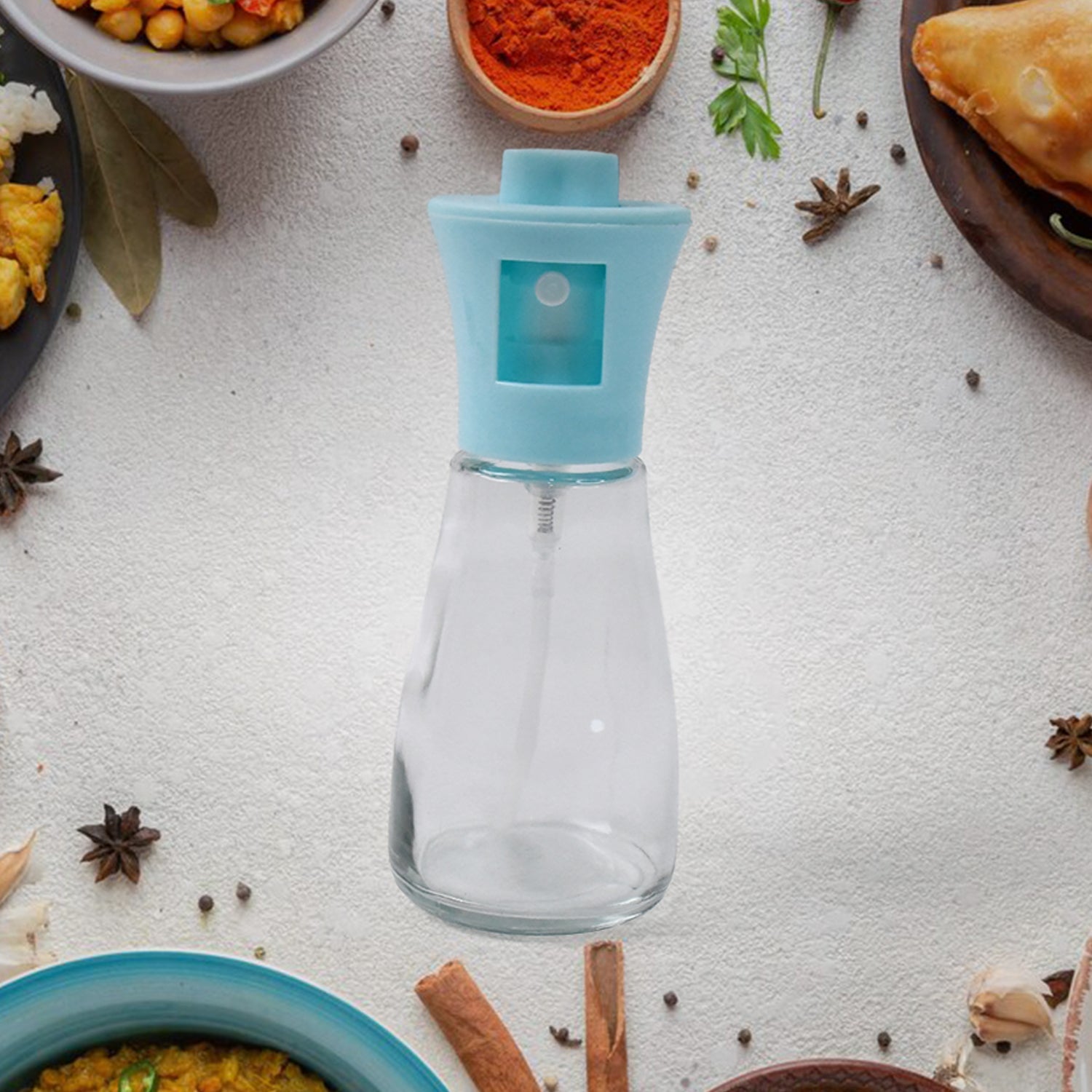 Fine mist spray from the oil dispenser bottle evenly coating food during cooking.