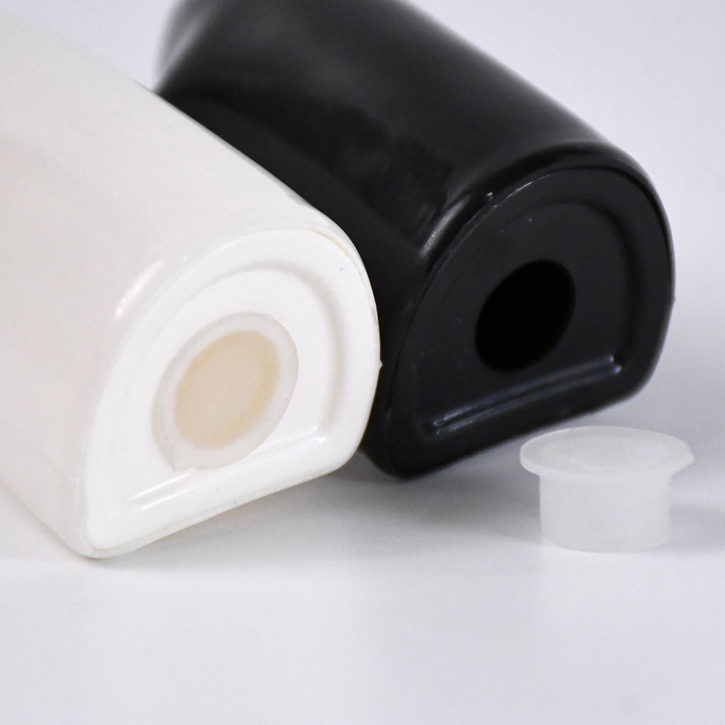 Two ceramic shakers, black and white, hugging as couple design