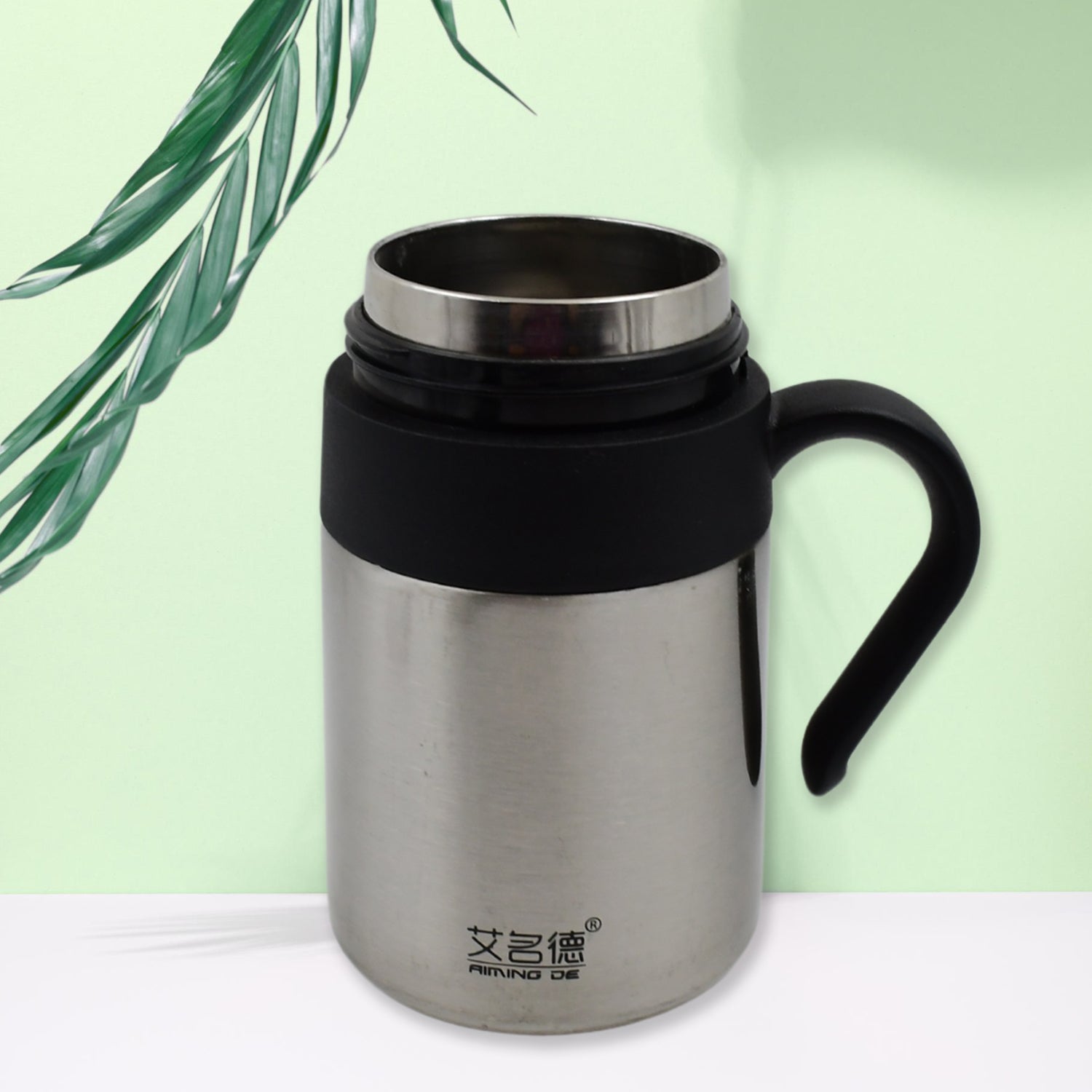 Person holding the Bottlart vacuum insulated mug with its ergonomic handle.