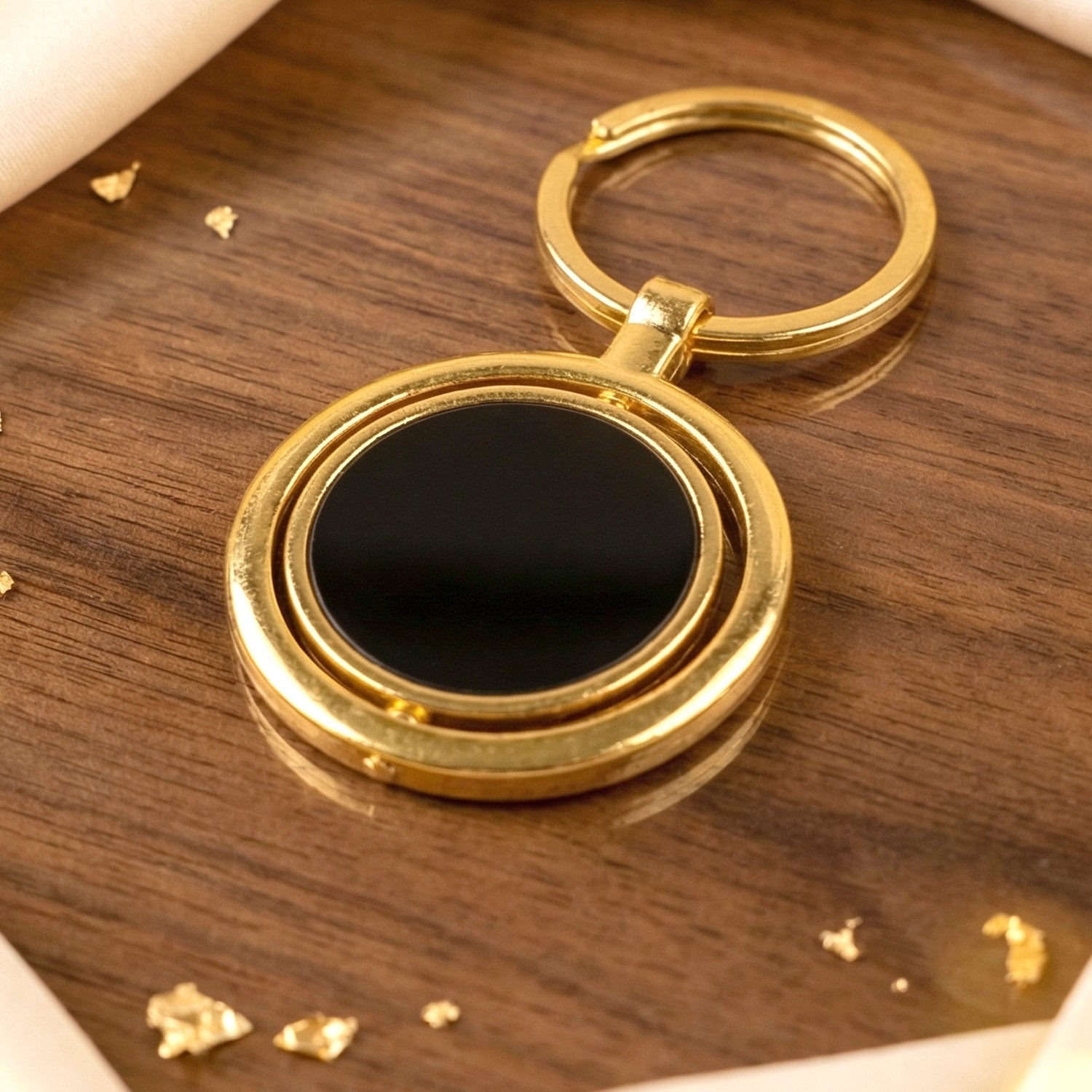 Durable gold plated keyring with black rotating pendant, versatile use.