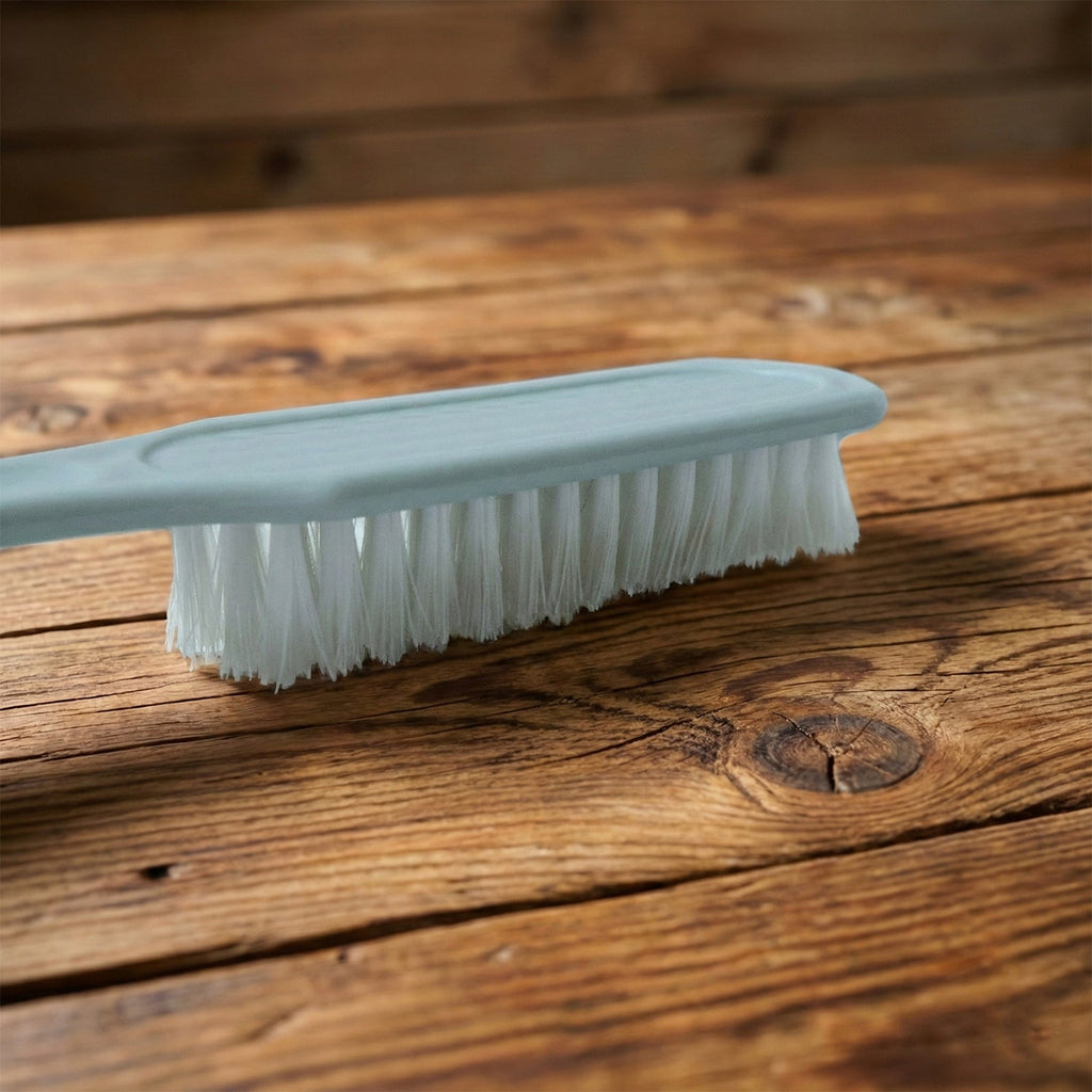 Side view of handheld cleaning brush showing ergonomic grip and bristles