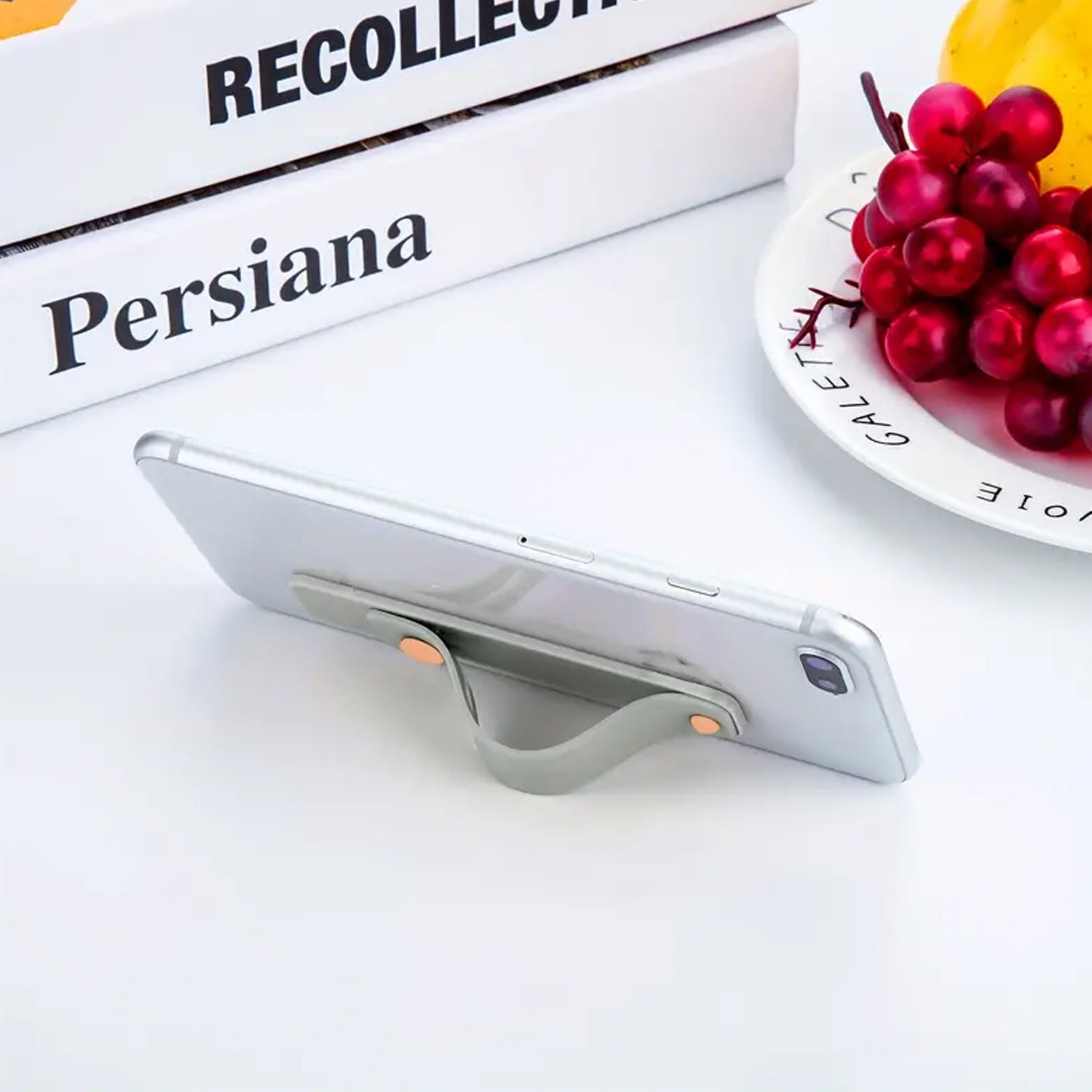 The flexible silicone phone grip strap detached from a phone, highlighting its stretchable material.