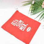 Red drawstring bag with daily essentials like a phone and keys.