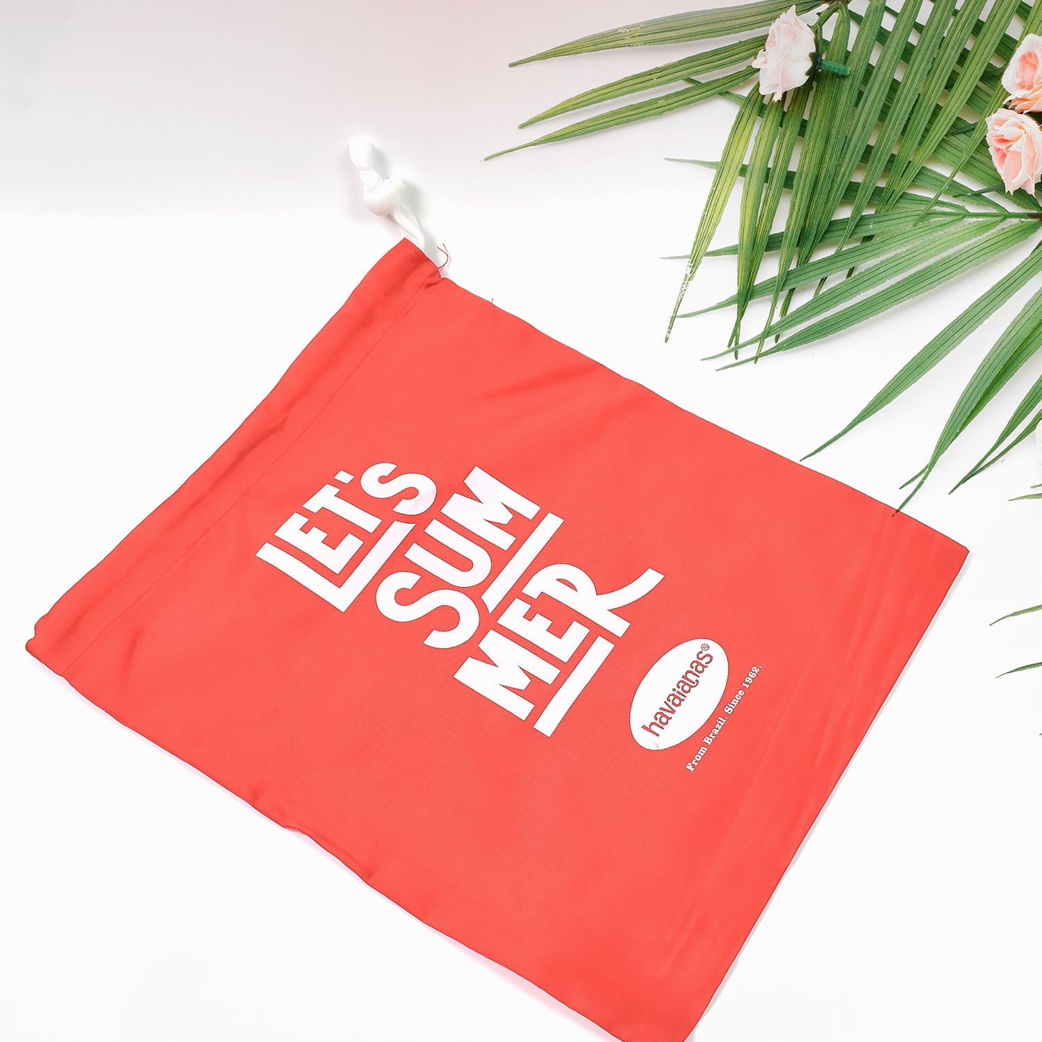 Red drawstring bag with daily essentials like a phone and keys.