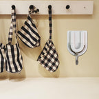 Practical adhesive wall hook holding a small purse, demonstrating its versatile use.