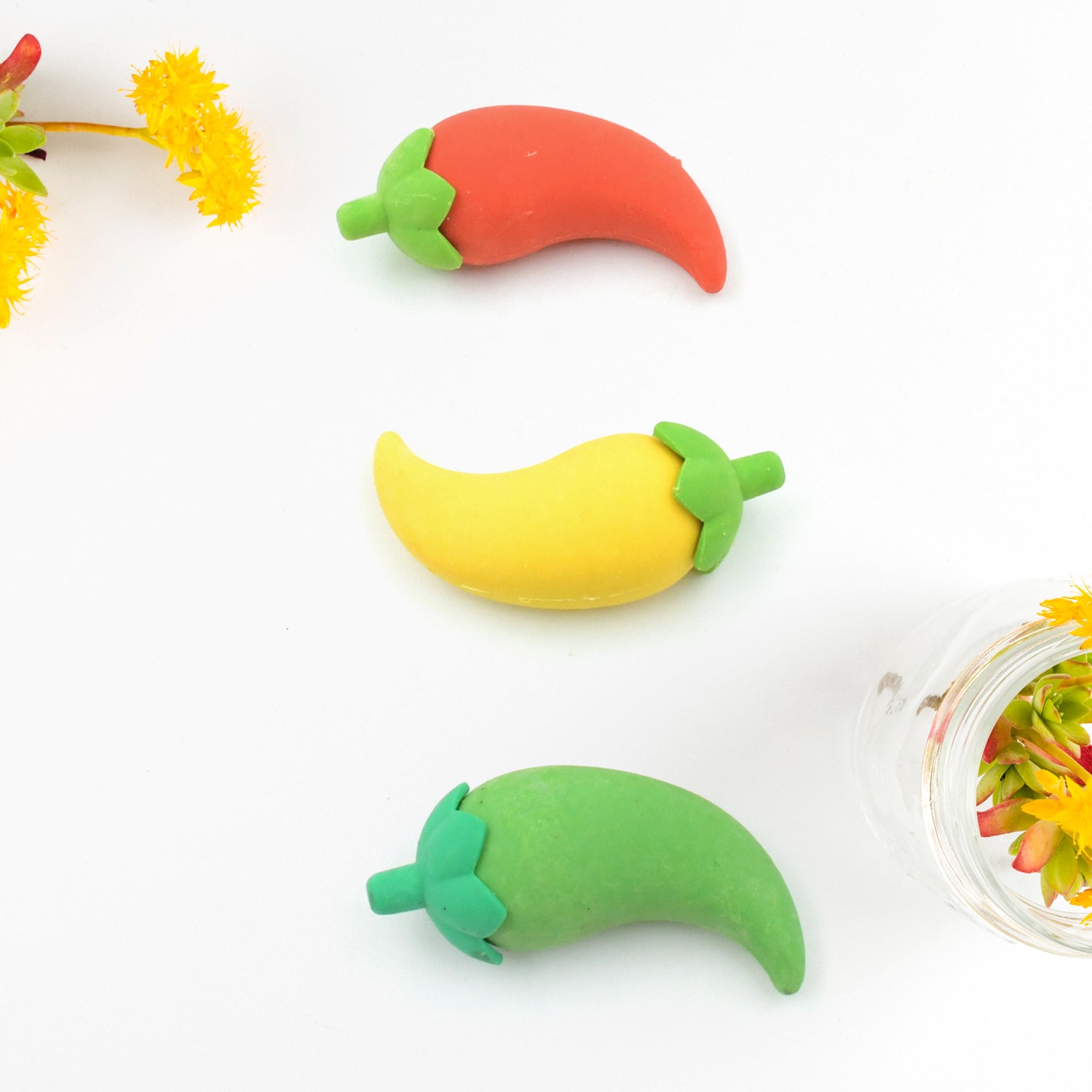 A playful arrangement of several 3D chili shape erasers in different colors.