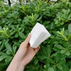 Soft cotton makeup remover pad held in hand to show gentle texture