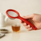 Ergonomic handled green tea strainer placed on wooden surface