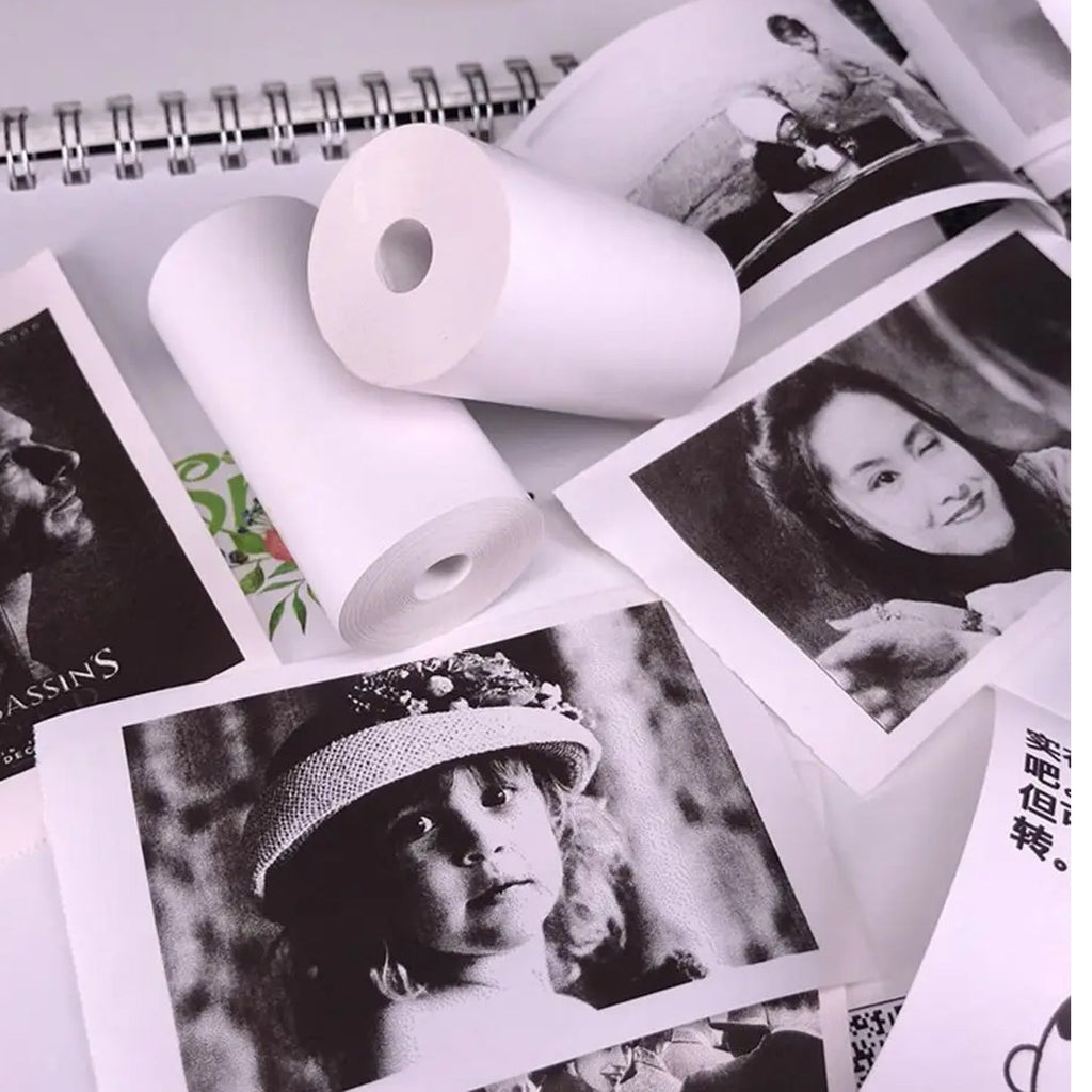 A hand carefully loading a fresh thermal printer paper roll into a compact printing device.