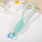 Various uses of the multipurpose strap, including attaching to keys and a camera, showcasing versatility.