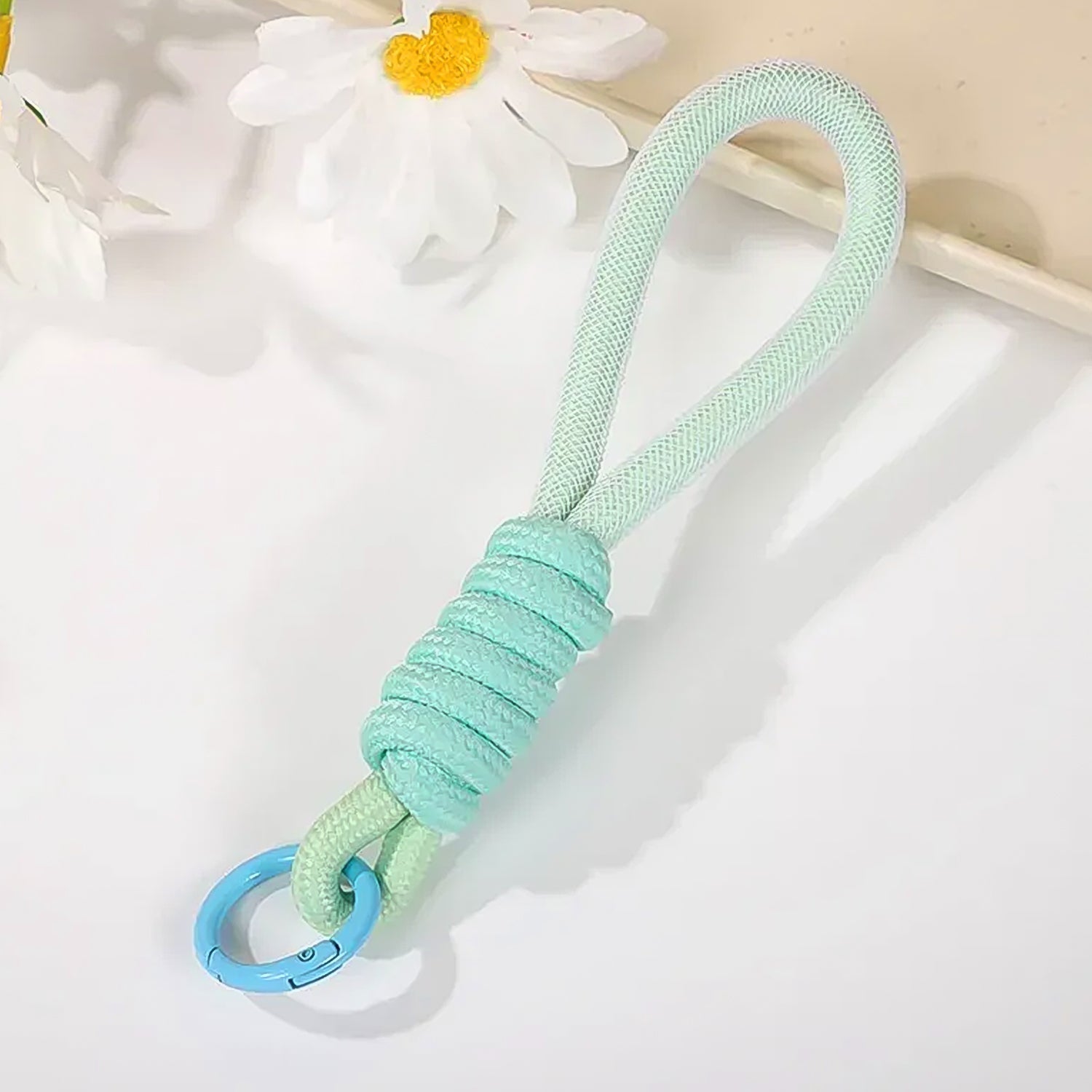 Various uses of the multipurpose strap, including attaching to keys and a camera, showcasing versatility.