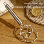 Stainless steel dough whisk ready for use in a clean kitchen setting.