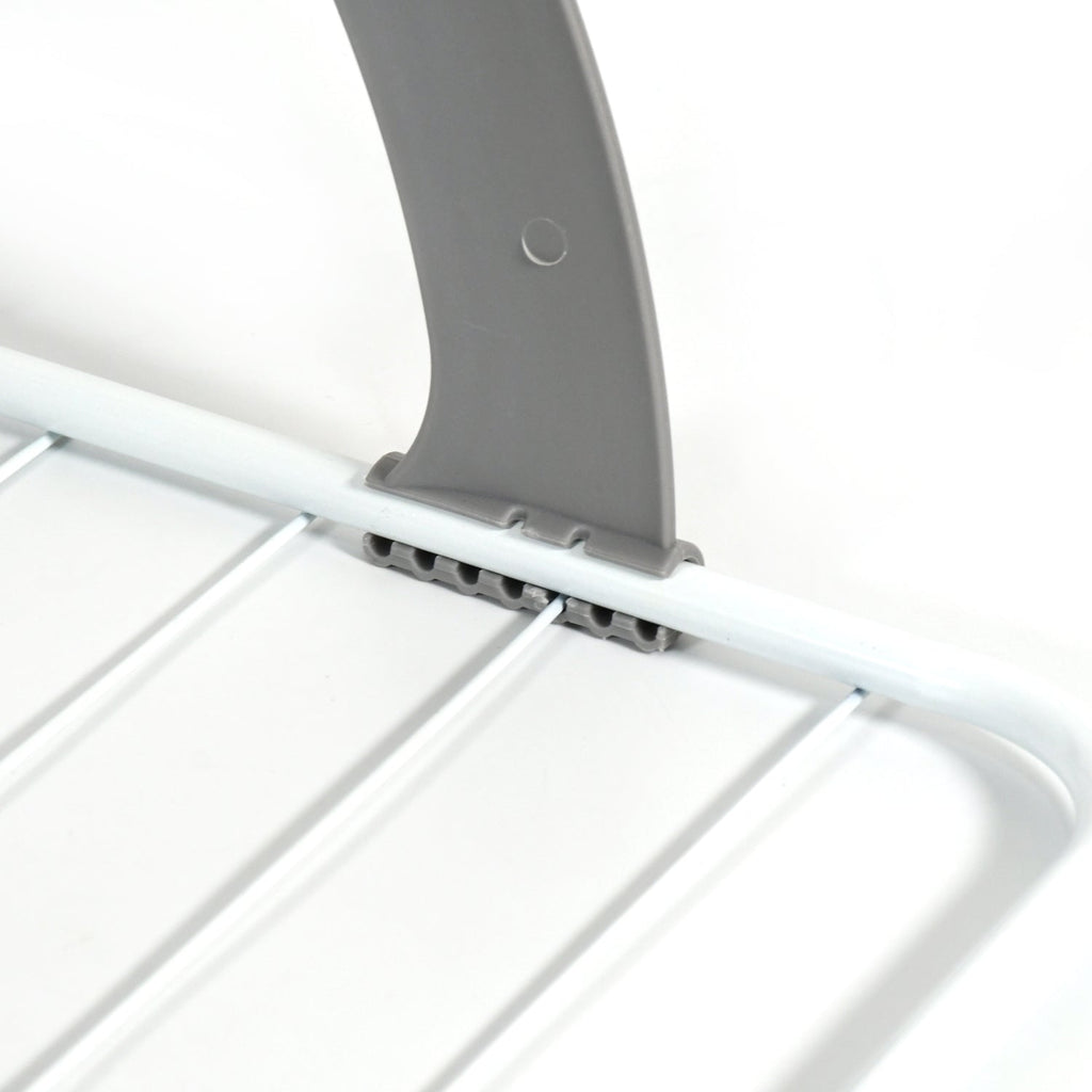 Folding drying rack neatly collapsed for compact storage under furniture or in a drawer.