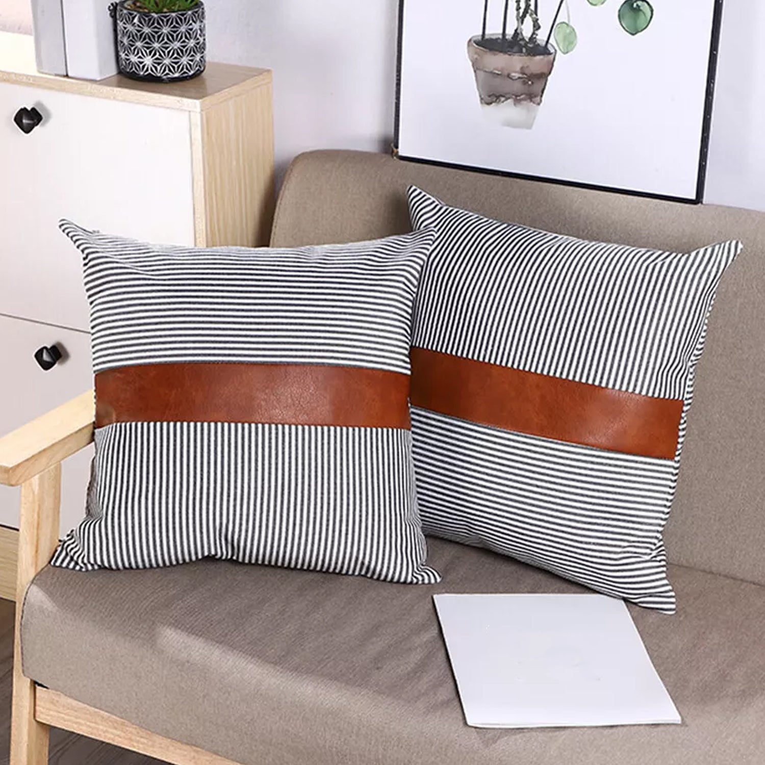 Close-up of a pair of 20x20 inch leather and cotton pillow covers