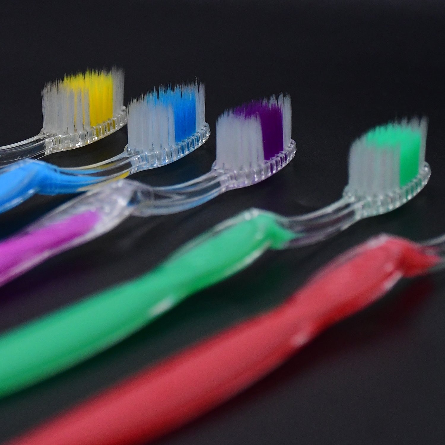 Collection of soft flexible plastic toothbrushes in a range of bright colours.