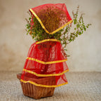 Close-up of red tulsi vastra cloth with gold border for religious offerings