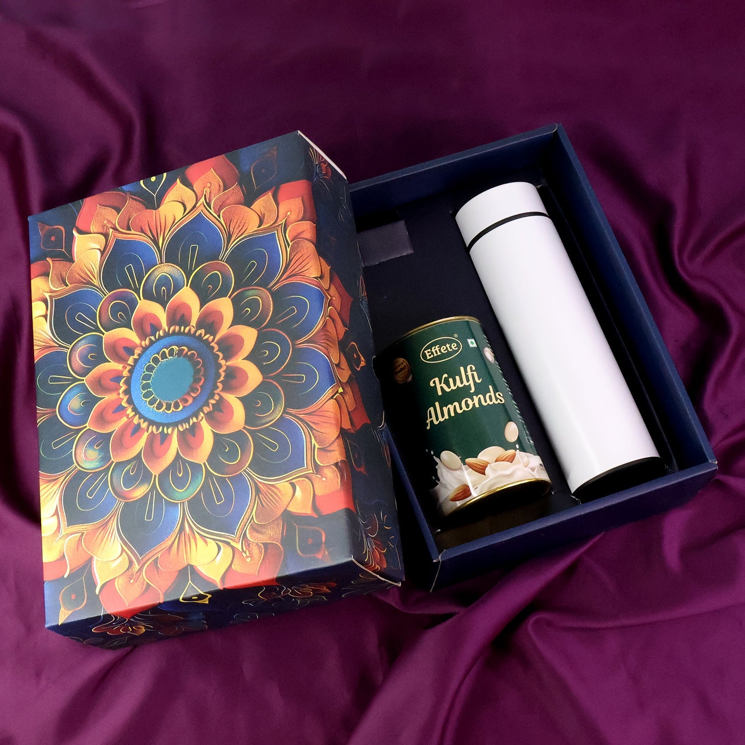 Golden festive gift box with kulfi almond chocolate and bottle inside