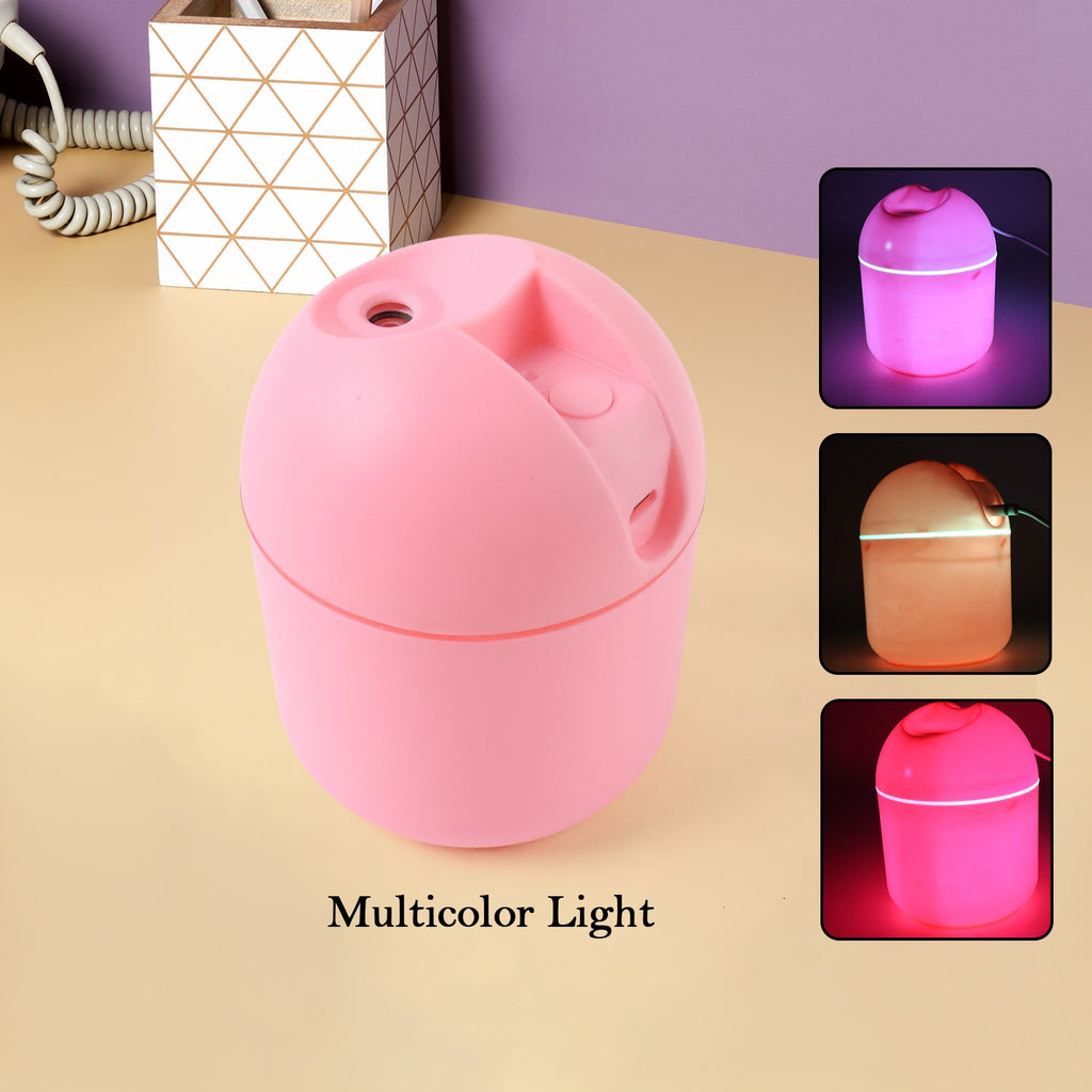 Small desktop humidifier with color-changing LED light on a wooden table.