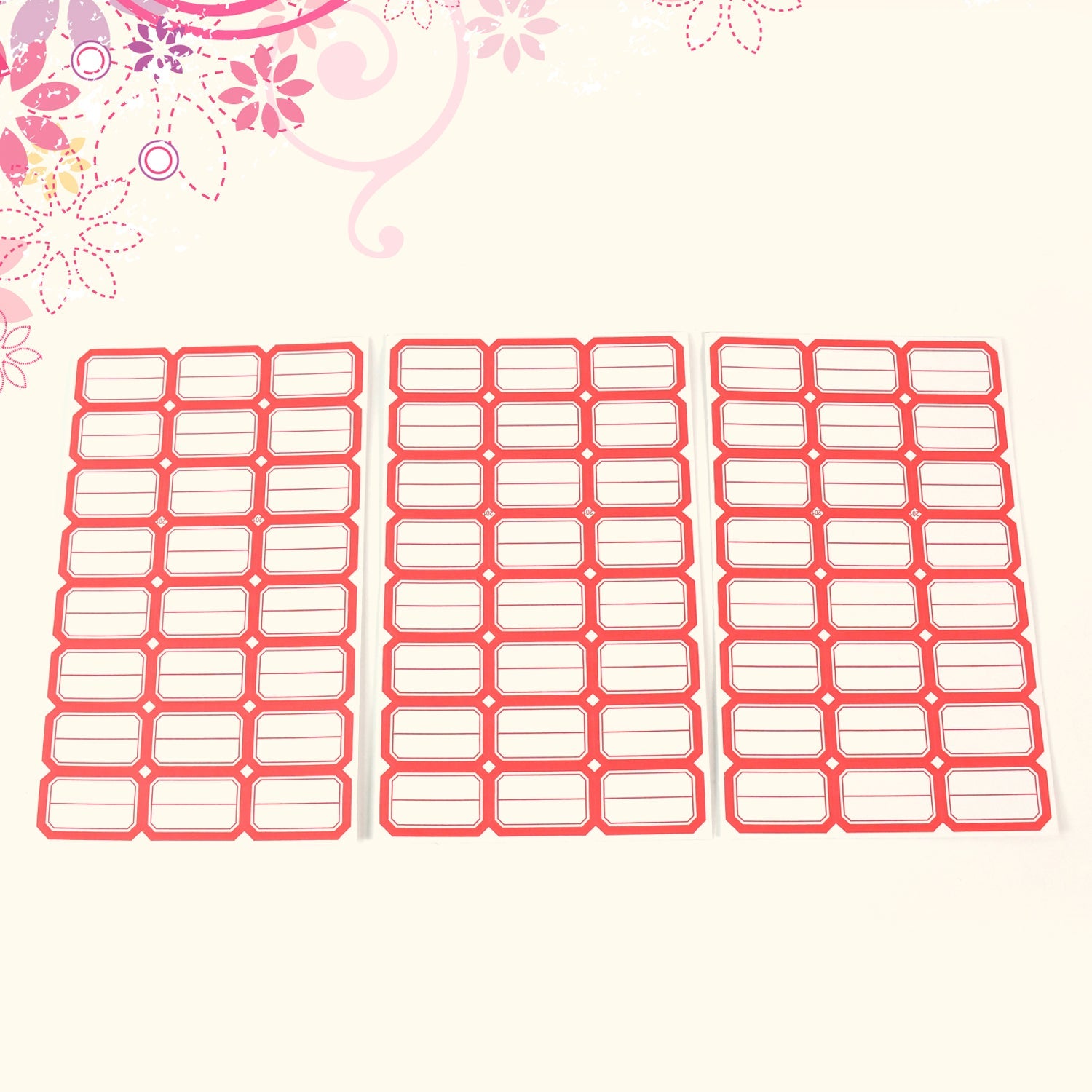 Overhead view of neatly arranged red border label stickers on a surface.