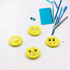 Children happily using the smiley emoji erasers while studying at a desk.