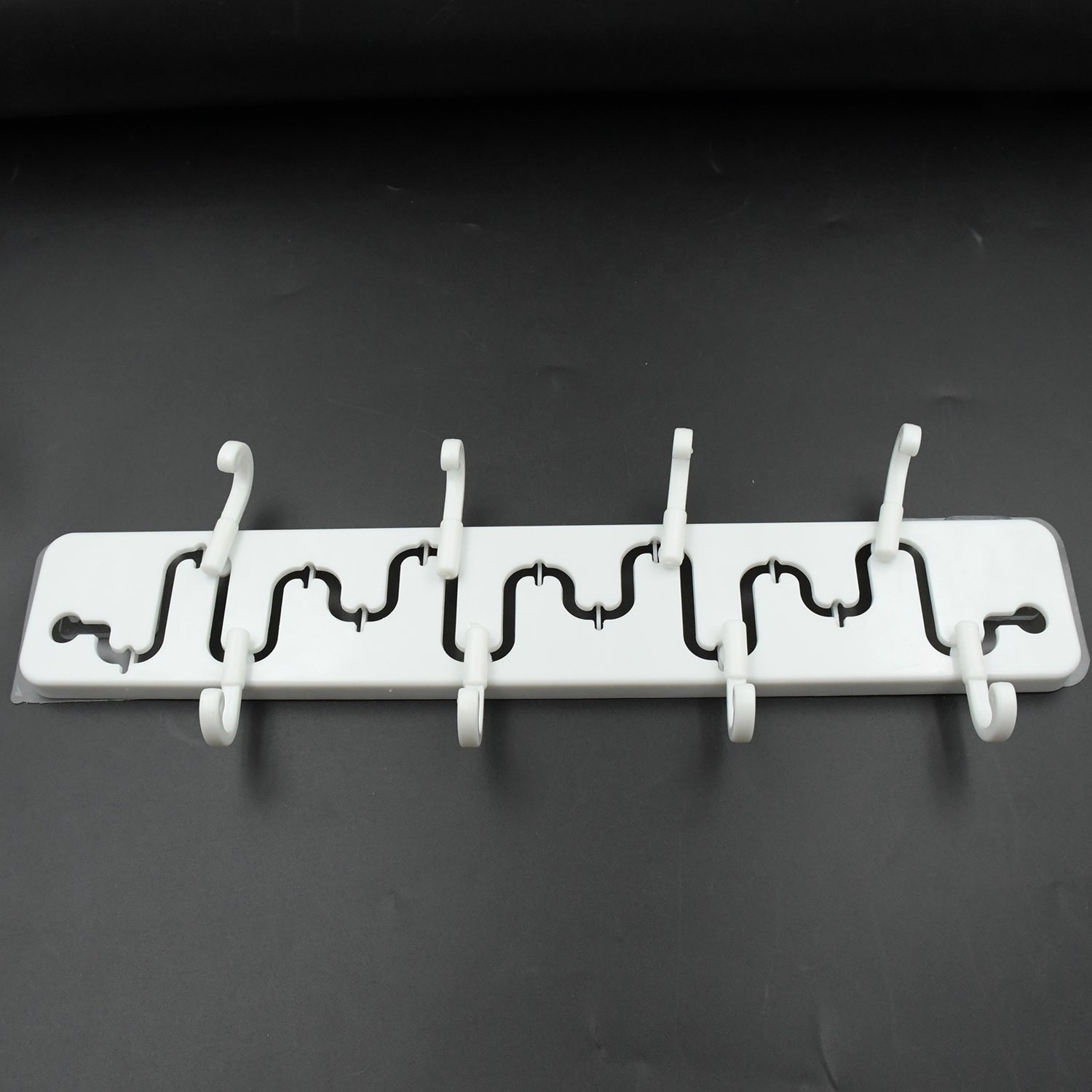 Modern adjustable wall hook installed in a bathroom, holding a towel.