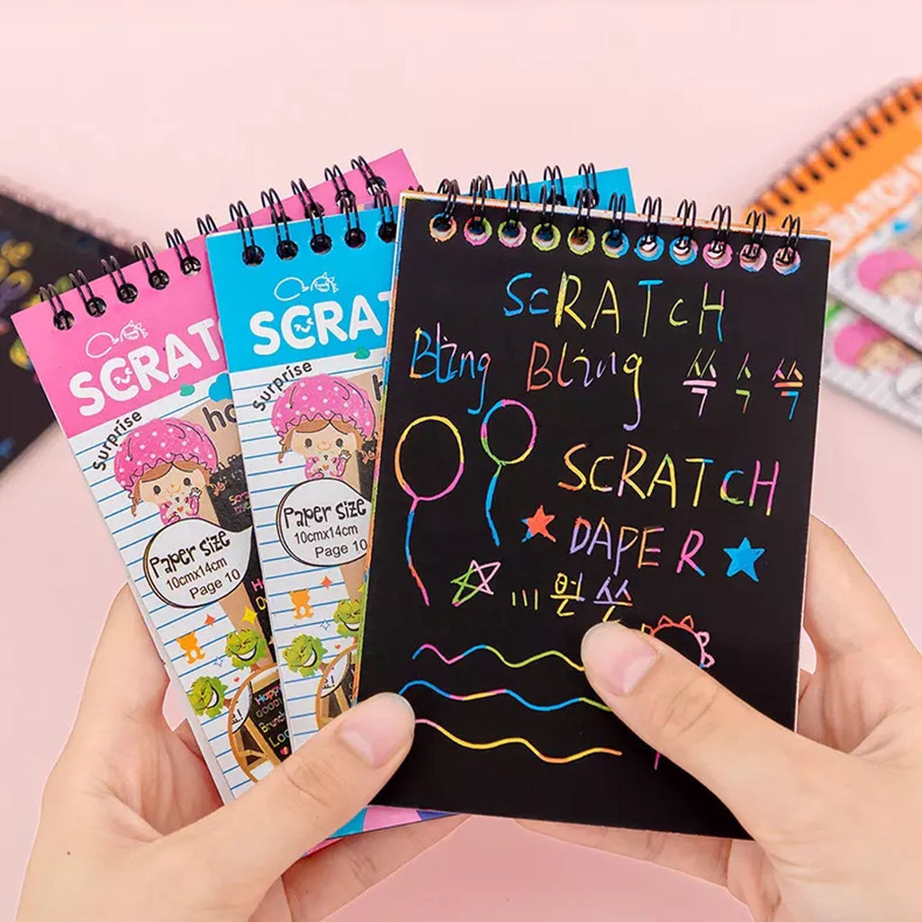 Top-down view of an opened rainbow art scratch book showing multiple colourful pages.