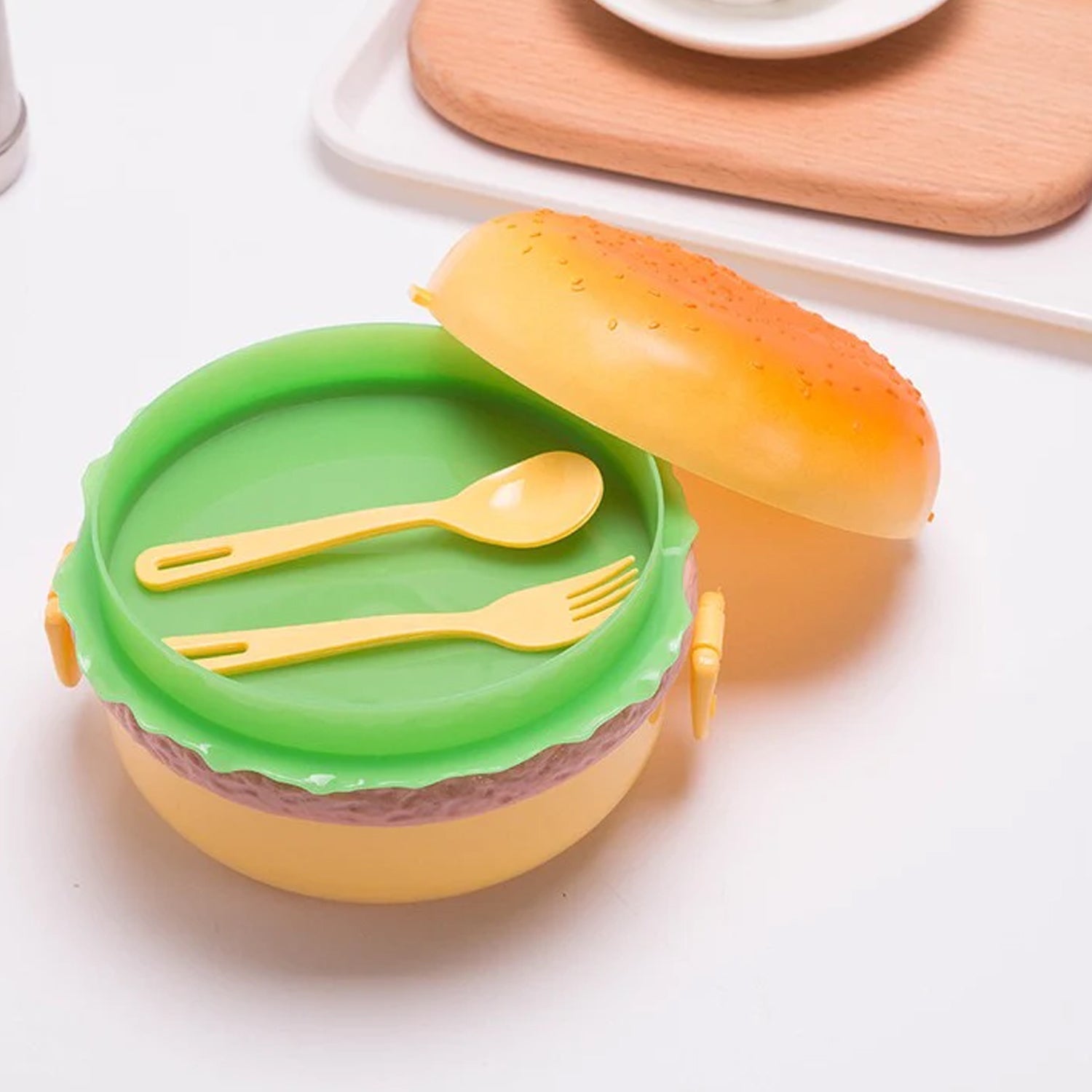 A closed burger shape lunch box, ready for school meals.