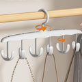 Rotatable 12-hook tank top hanger holding multiple tank tops in a modern closet.