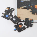 Child assembling educational solar system puzzle with labeled planet pieces