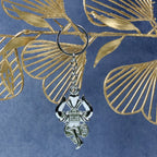 Side angle view of silver Trishul Damru keychain highlighting craftsmanship