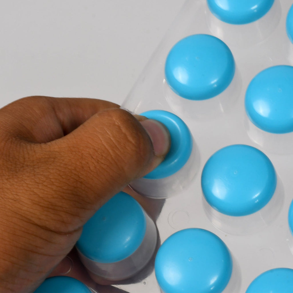 Multiple colorful round silicone ice cube trays filled with frozen ice spheres.