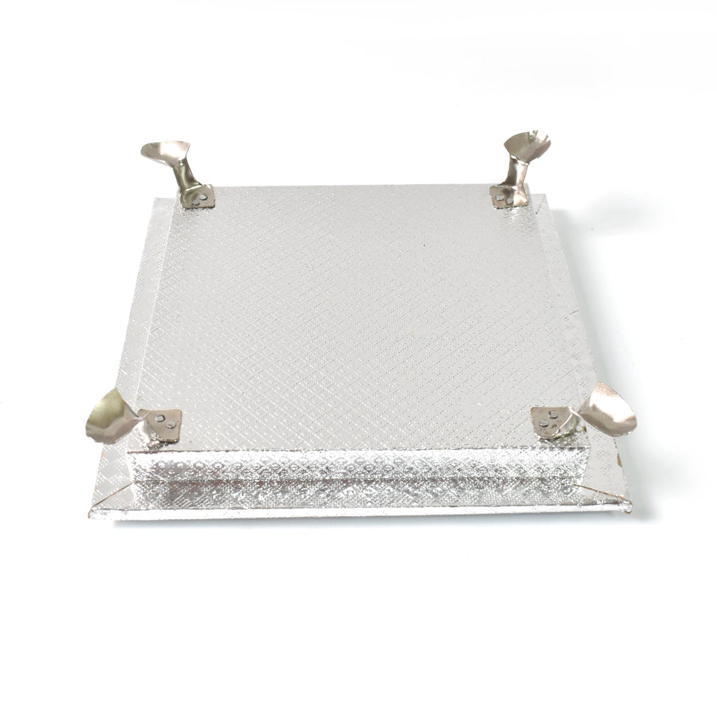Silver pooja platform with a serene Ganesha carving, ideal for home temples and altars.