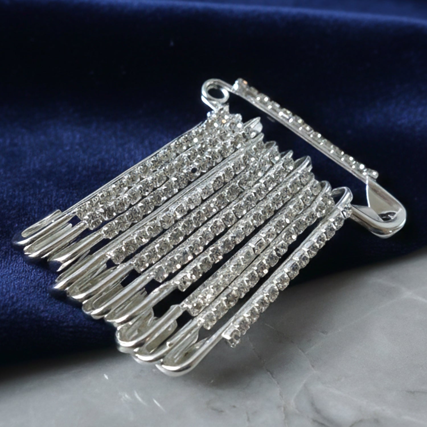 Silver safety pin brooch with crystal attached to a scarf