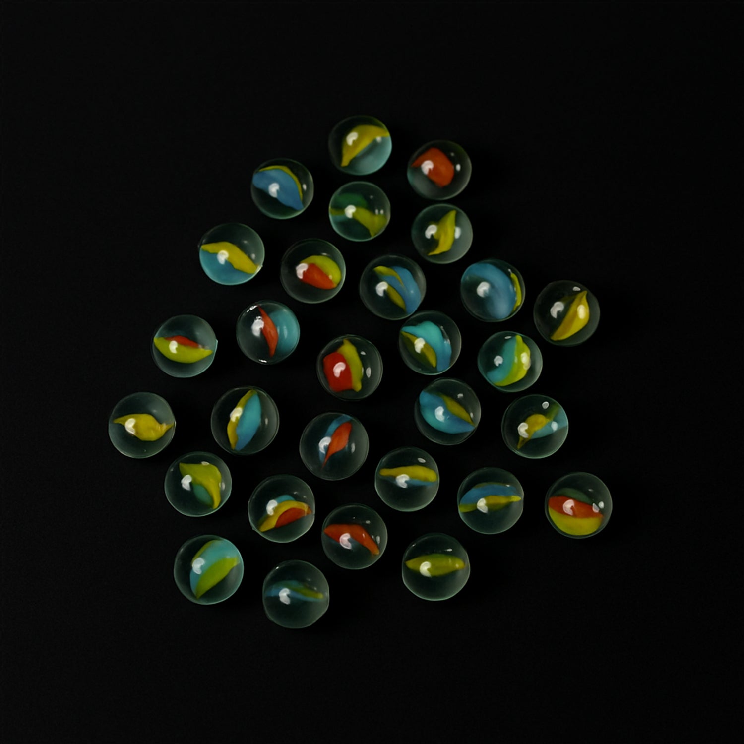 Glass marbles displayed with colorful swirl designs, ideal for kids and crafts