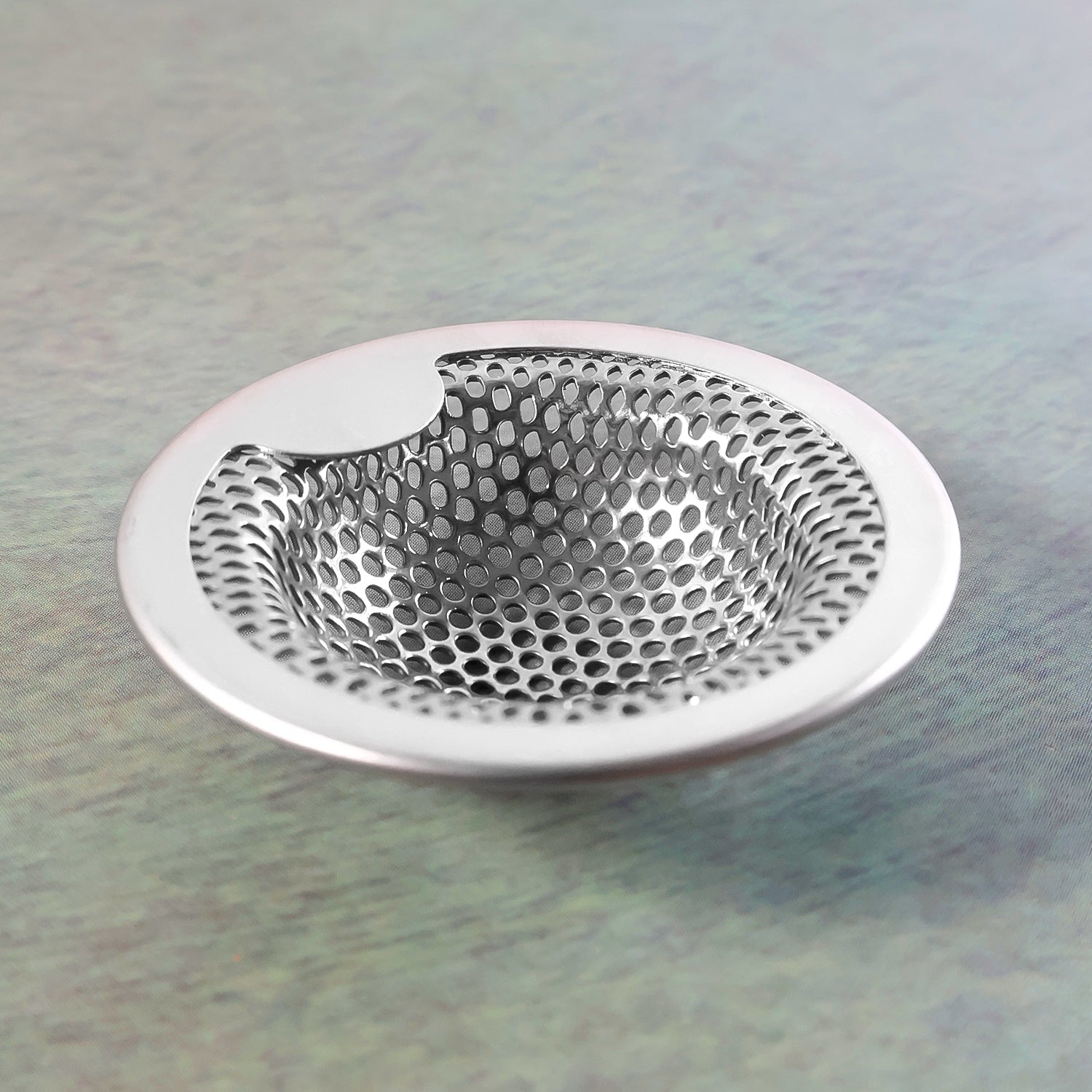 Kitchen sink strainer showing rust-resistant steel surface and holes