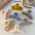 Detailed view of a plush hair clip, highlighting its durable plastic base and fluffy exterior.