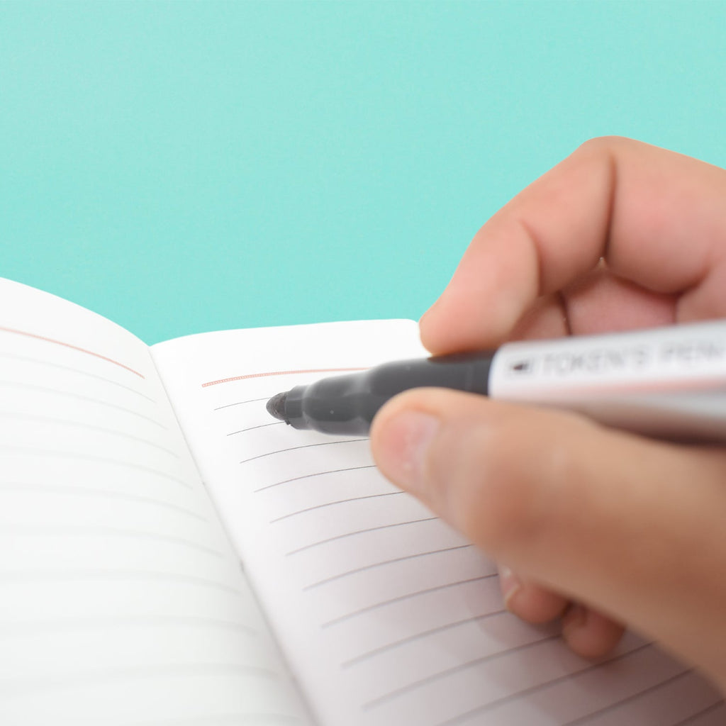 A hand demonstrating the comfortable grip of a black marker, emphasizing its ergonomic design.