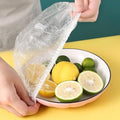 Small elastic food covers stretched over various bowls of fresh food on a kitchen counter.
