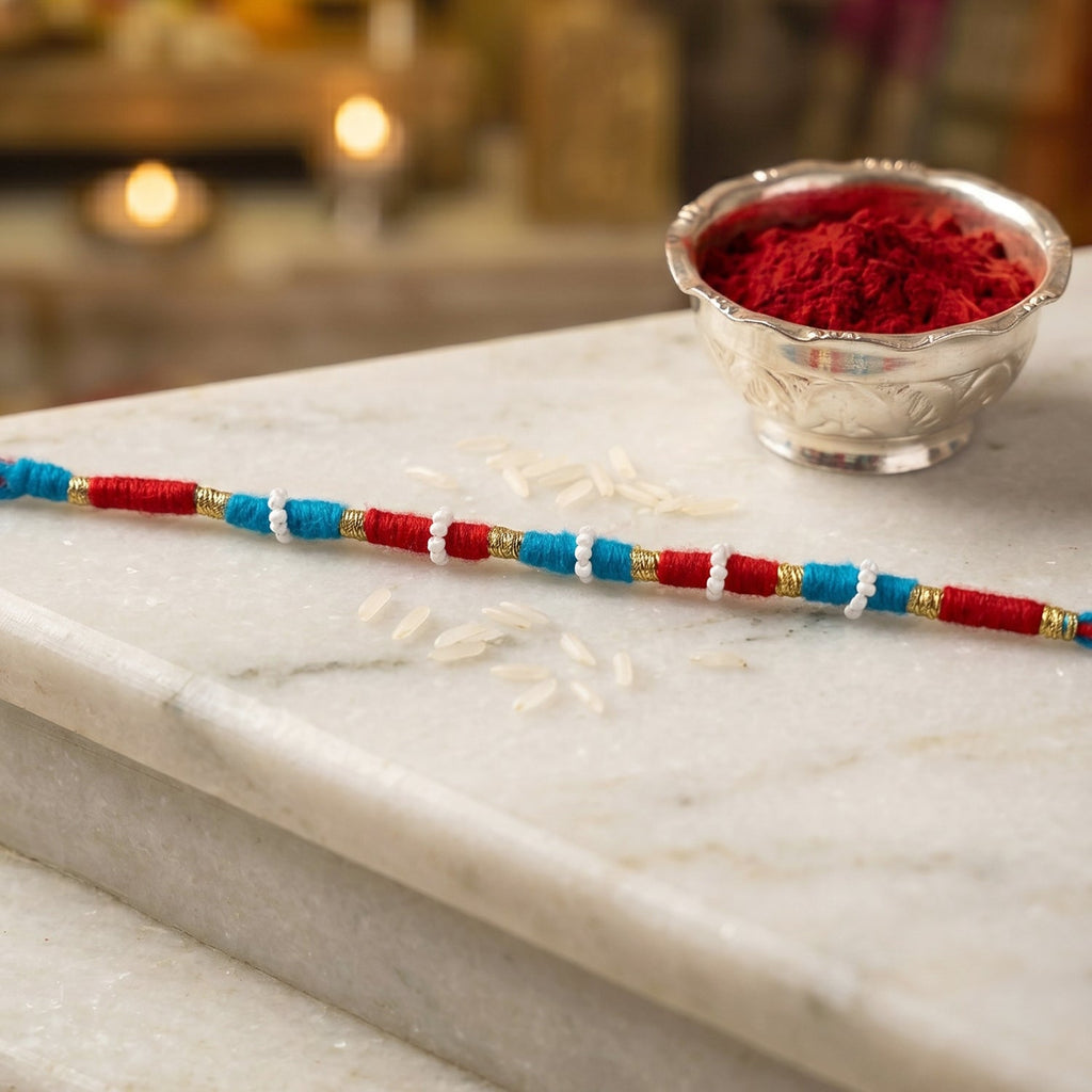 Decorative red rakhi thread bracelet with gold accents