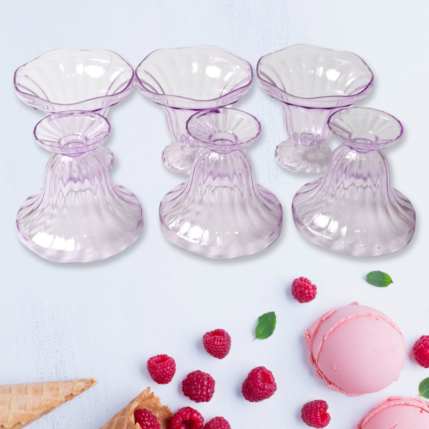 Clear plastic serving bowls displayed with various fruits and snacks.